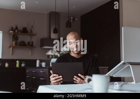 Smiling businessman using digital tablet while working at home Stock Photo