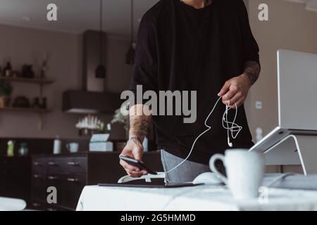 Midsection of businessman using smart phone while working at home Stock Photo