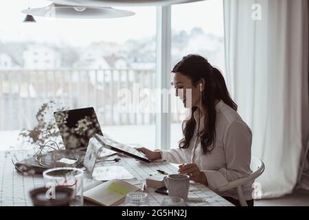 Smiling businesswoman using digital tablet at home office Stock Photo