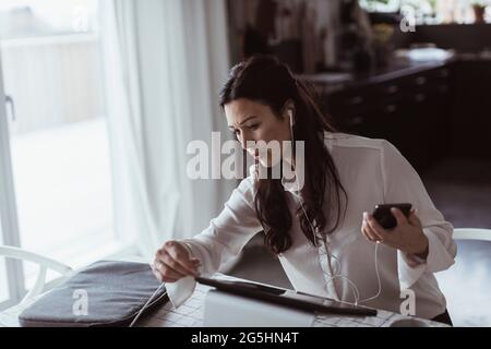 Businesswoman using digital tablet while working at home office Stock Photo
