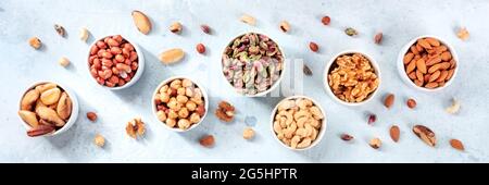 Nuts panorama on a slate background. Peanuts, walnuts, almonds and various other nuts, top shot Stock Photo