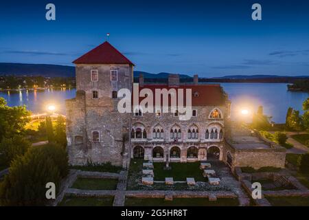 Tata, Hungary - Aerial view of the beautiful illuminated Castle of Tata by the Old Lake (Oreg-to) at dusk with clear blue sky on a summer night Stock Photo