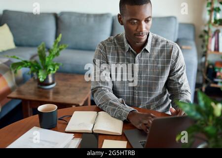 Young African businessman working on a laptop at home Stock Photo