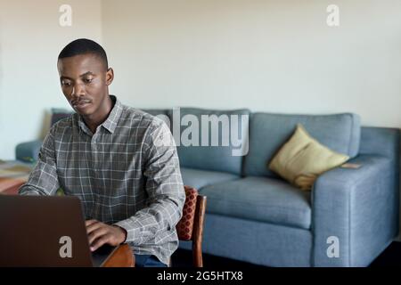 Young African businessman working from home using a laptop Stock Photo