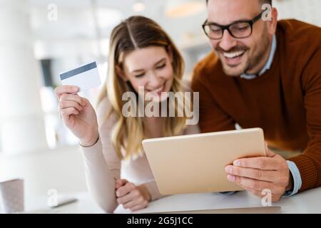 Cheerful young couple doing online shopping with tablet Stock Photo