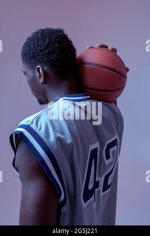 Basketball player poses with ball, back view Stock Photo