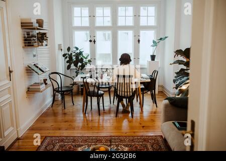 Full length rear view of male entrepreneur working in home office Stock Photo