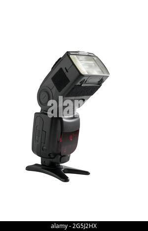 A professional, expensive external remote photography digital travel flash standing on a table tripod, cut out on white background with copyspace. Stock Photo