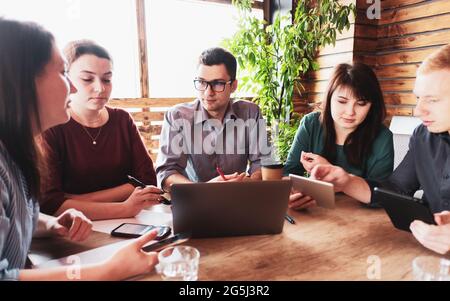 Businessman meets with his colleagues in the office - A group of millennials are discussing a new project - The concept of teamwork finding a developm Stock Photo
