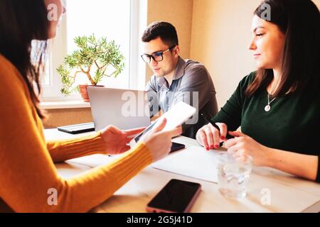 A group of young colleagues are working on a startup - Colleagues and employees are busy with office work - Team work of young people in the office on Stock Photo
