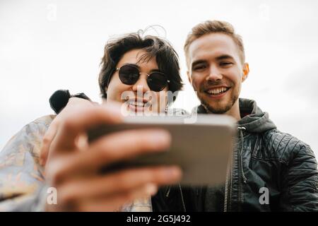 Happy multi-ethnic male friends taking selfie on mobile phone Stock Photo