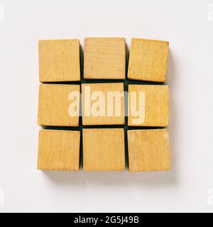 Nine wooden blocks of cubes on gray background with copy space for text - Concept of creating, building and merging Stock Photo