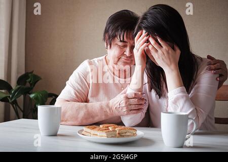 Mental disorder and support from relatives - Depression of the daughter and consolation from her grandmother - The concept of family relationships and Stock Photo