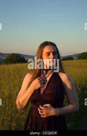 Teenage girl standing in a field in rural Germany on a warm spring night. Stock Photo