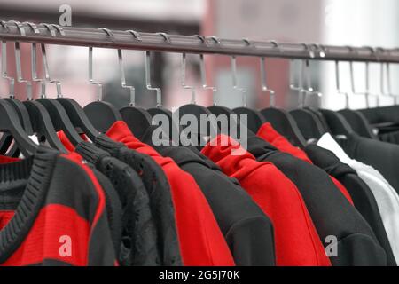 Textile knitted sweaters and sweaters hang on wooden hangers Stock Photo