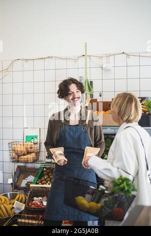 Smiling male owner talking with female customer in store Stock Photo