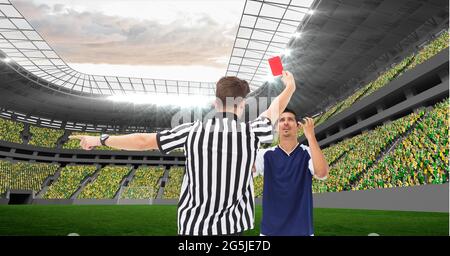 Composition of male referee holding red card and player at football stadium Stock Photo