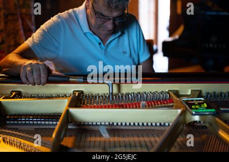Man tuning a concert grand piano Stock Photo