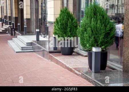 pedestrian walkway made of stone tiles along the building with thresholds and steps with entrances to shops lined with granite with decorative street Stock Photo