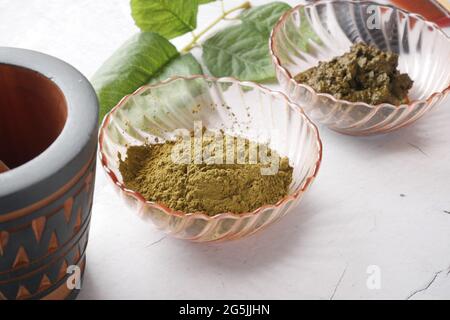 The wooden bowl with rehydrated henna on table Stock Photo