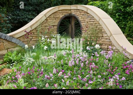 Drystone wall with window, planting of Aquilegia and Persicaria Stock Photo