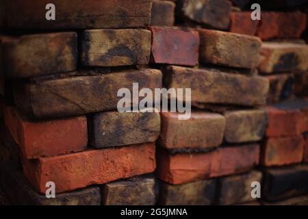 stack of old red black bricks background. Stock Photo