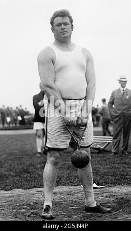 Matt McGrath holding a 56lb weight (1911) - He was an athlete representing America at the Summer Olympics, winning a Gold Medal in 1912 in Stockholm Stock Photo