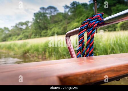close up of rope on  canal boat tied to chrome rail Stock Photo