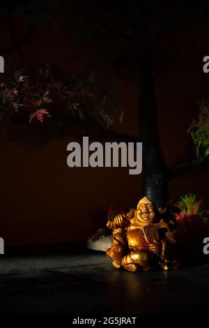 Laughing Buddha Statue on under the Tree. Statue of Laughing Buddha. Statue of Kubera. Stock Photo