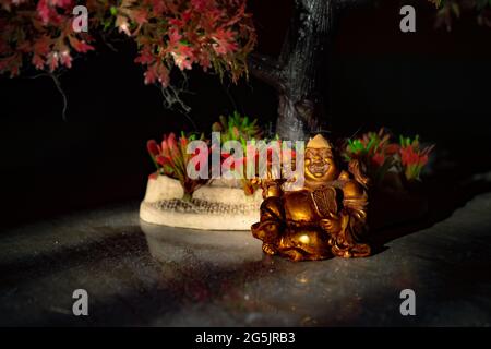 Laughing Buddha Statue on under the Tree. Statue of Laughing Buddha. Statue of kubera. Stock Photo