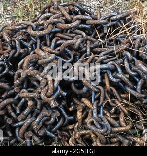 Old rusty industrial heavy duty chains lying at a workplace in sormland, Sweden Stock Photo