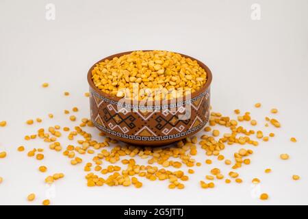 Close-up of Organic Bengal Gram (Cicer arietinum) or split yellow chana dal inside a  bowl. White isolated background. Stock Photo