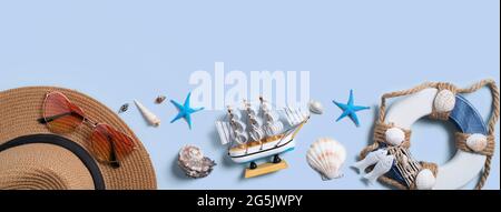 Summer beach background design concept. Top view of holiday travel with shells, hat and sunglasses on blue background. Stock Photo