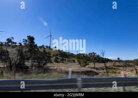 Electricity generating windmill Farms Hume Highway NSW Australia taken from moving car blurred foreground Stock Photo