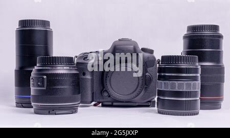 collection of camera equipment including a camera body and four lenses on a white background Stock Photo