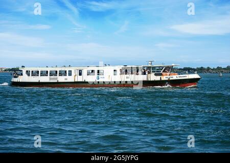 Actv (municipal company for public transport) Ferry Boat or Vaporetto crowded with tourists in motion in the Venice Lagoon on a sunny spring day. Stock Photo