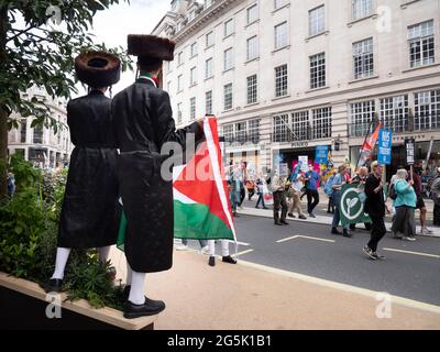 Ultra Orthodox Jews of the Neturei Karta division  from Stamford Hill who represent Orthodox Jews United Against Zionism amongst flags of Palestine attend  the People's Assembly National Demonstration in London. Rabbi Blyer is on right Stock Photo