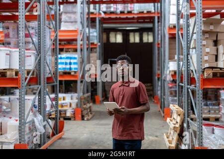 Serious manager of large warehouse using digital tablet Stock Photo
