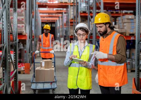 Two warehouse employees with tablet discussing working points Stock Photo