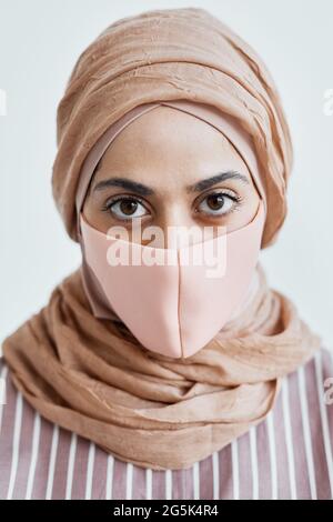 Vertical close up portrait of modern Middle-Eastern woman wearing mask and looking at camera Stock Photo