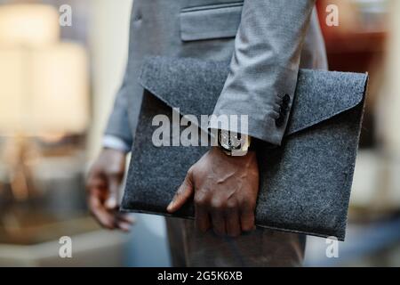 Close up of successful businessman holding document folder while standing in lobby, focus on expensive watch, copy space Stock Photo