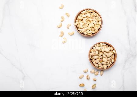 Cashew and pistachios nuts in wooden bowls Stock Photo