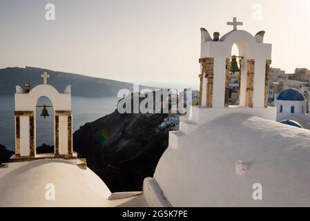 Rainbow on the volcanic soil of Santorini Island with bell towers overlooking the caldera in Greece. Stock Photo