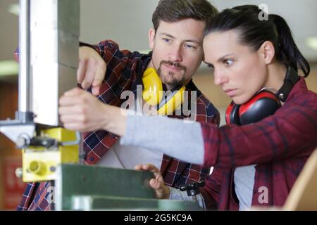 two engineers operating cnc machinery on factory floor Stock Photo