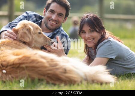 couple outdoors with their golden retriever dog Stock Photo