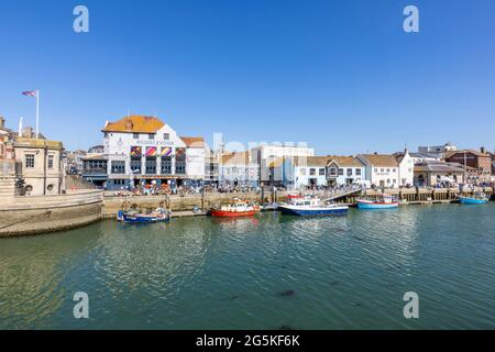 Boats moored quayside in Weymouth, a seaside town and popular holiday resort on the estuary of the River Wey in Dorset, south coast England Stock Photo