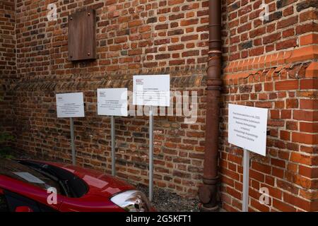 Gniezno, Poland - Information noise, excess messages on placards in front of an architectural monument, the Holy Trinity parish church. Stock Photo