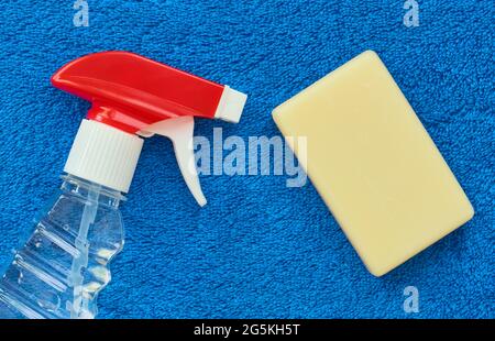 Disinfectant spray and toilet soap on a blue terry towel, hygiene products in a close up Stock Photo