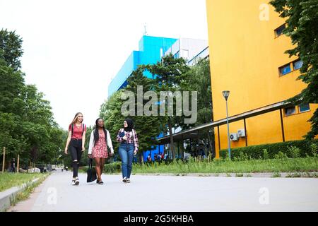 Three friends walking around their school grounds Stock Photo