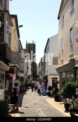 The shops along Foss Street in the Devon town of Dartmouth with the church of St Saviour's in the background. Stock Photo